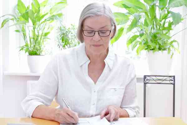Ältere Dame bearbeitet Unterlagen